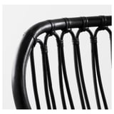 Naslon stolice od crnog tkanog ratana, stručno izrađen, prikazuje zamršene uzorke i čvrst dizajn.