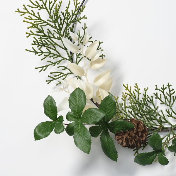 Umjetni cvjetni aranžman sa zelenim lišćem, bijelim cvjetovima, šišarkom na stabljici.