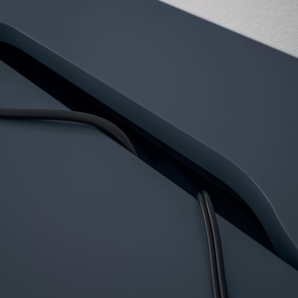 Sötétkék íróasztal ívelt élekkel és beépített kábelrendező hornyokkal.