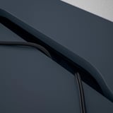 Sötétkék íróasztal ívelt élekkel és beépített kábelrendező hornyokkal.