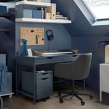 Szürke ALEX íróasztal fiókokkal, polcokkal, billentyűzettel, monitorral és székkel.