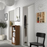 Modern bejárat BILLY könyvespolccal, zöldelléssel, székkel és geometrikus fallal.