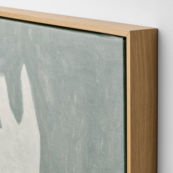 Közeli kép a természetes tölgyfa kerettel ellátott vászonképről, amely kiváló minőségű anyagokat és kézműves munkát mutat be.