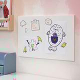 Színes mágnestábla rózsaszín falon rajzokkal, jegyzetekkel és bárányfigurával.