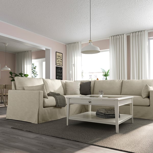 Modern nappali bézs színű HYLTARP szekcionált ruhával, dohányzóasztallal, szürke párnákkal, fapadlóval, nagy ablakokkal.