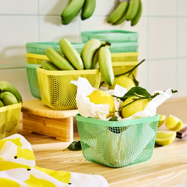 Hálós kosarak gyümölcsök tárolására, citrommal elöl a pulton.