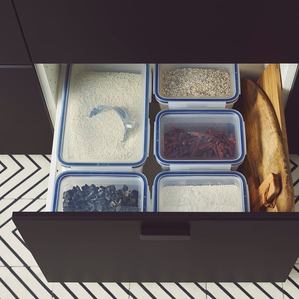 Öt átlátszó doboz tárolja a különféle szárazárukat egy fiókban, bemutatva az IKEA 365+ rendszerezését.