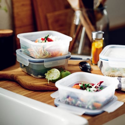 Fából készült pult átlátszó ételtartókkal, színes ételekkel, lime-mal és fűszeres üveggel. Halmok a helytakarékosság érdekében.
