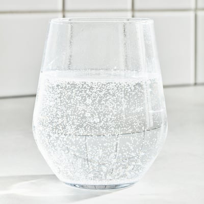 Egy üveg átlátszó ISKUB citrom és lime ízű ital az IKEA-tól, alacsony cukorszintűként és természetes ízesítéssel.