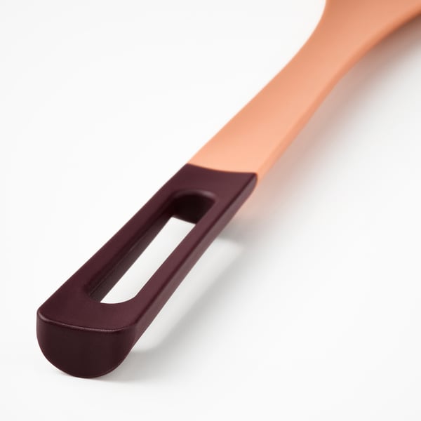 Közeli kép egy modern, színes főzőkanálról ergonomikus fogantyúval és szilikon heggyel.