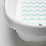 Fehér babakád puha, ívelt élekkel és texturált, zöld csúszásgátló felülettel, amelyet a biztonság és a stabilitás érdekében terveztek.