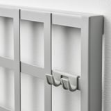 Modern fehér rendszerező erős kampókkal, falra szerelésre tervezve. Elegáns élei és kiváló minőségű felülete praktikus tárolást kínál.