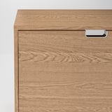 Egy fából készült cipősszekrény közeli képe, amely sima felületét és masszív fogantyúját mutatja be. Minőségi kivitelezés tiszta, természetes erezetmintákkal.