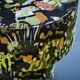 Élénk asztali lámpa bonyolult vászonszövettel, részletgazdag erdei mintával, kiváló minőséget és kézművességet árasztva.