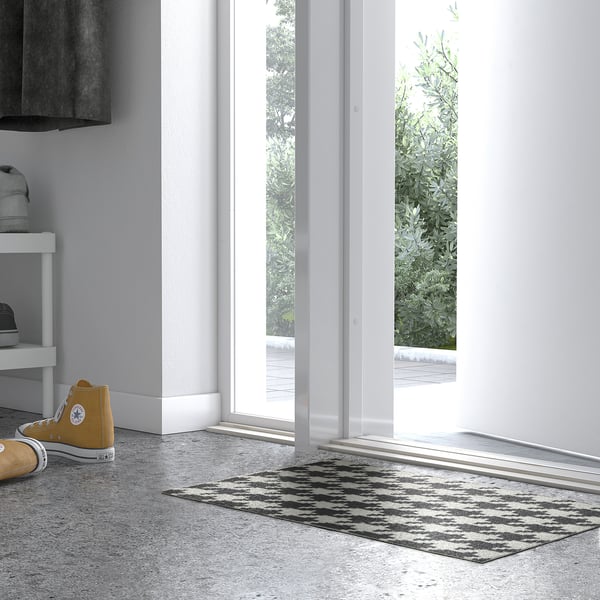 Minimalista bejárat TOMTRÄTT szőnyeggel, cipőtartóval és kilátással a szabadba.
