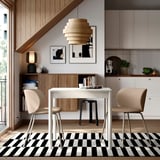 Modern étkező TONSTAD fehér asztallal és bézs színű székekkel fekete-fehér szőnyegen, fa díszítéssel, földszinti tárolóval és függőlámpával.