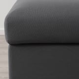 A képen egy puha, sötétszürke kanapé közeli képe látható, sima, tartós anyaggal, kiemelve annak kényelmes és kiváló minőségű textúráját.
