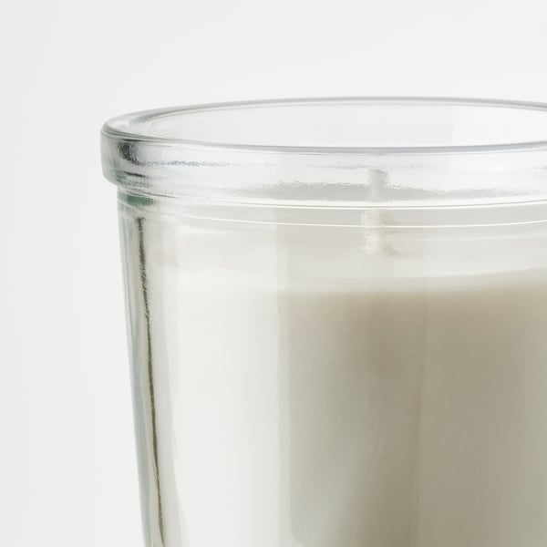 Clear glass candle holder half-filled with creamy white wax, high-quality, handmade look.