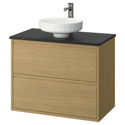 Modern bathroom vanity, light wood, dark countertop, round basin. Minimalist design.