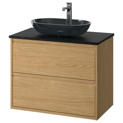 Modern light oak vanity, dark glass oval sink, wall-mount design.