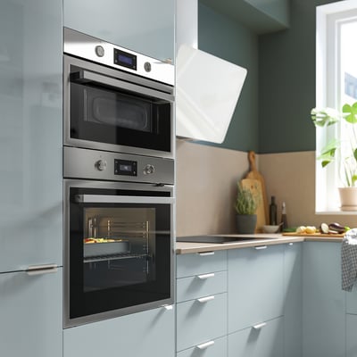 Modern silver oven with digital display, glass door, and stainless steel frame. Easy-to-use controls and telescopic racks.