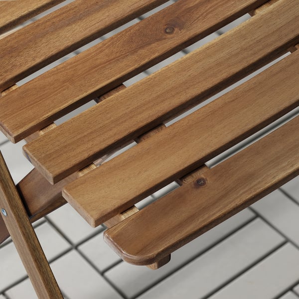 Close-up of smooth, slatted acacia wood outdoor furniture, showcasing natural grain and polished finish.