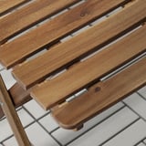 Close-up of smooth, slatted acacia wood outdoor furniture, showcasing natural grain and polished finish.