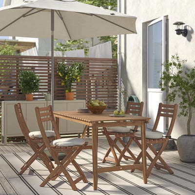 Acacia dining set with umbrella & cushioned chairs on deck.