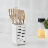Wooden utensils in white drying rack with holes for air circulation on counter.