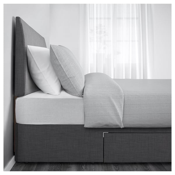 Grey bed with two large drawers underneath for extra storage.