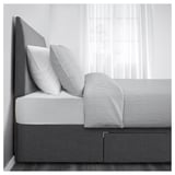 Grey bed with two large drawers underneath for extra storage.