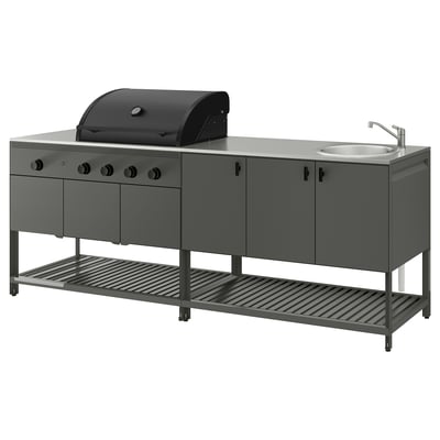 The BÅTSKÄR outdoor kitchen set includes a black gas grill, sink, and storage units with a sleek grey finish. Ideal for outdoor cooking.