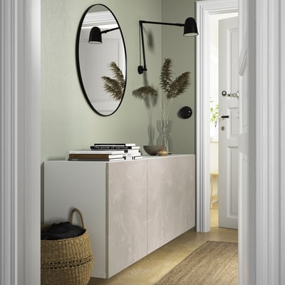 Modern hallway with beige marble sideboard, books, and mirror.