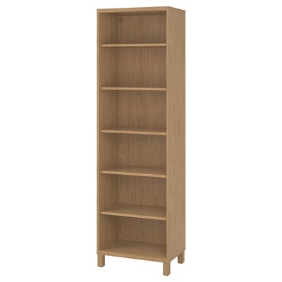 An upright BESTÅ light brown bookshelf with five shelves, crafted from wood.