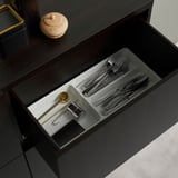 Open drawer with flatware organizer and small tools, showing adjustable compartments and soft-close feature.