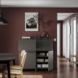Maroon living room with BESTÅ storage unit, decor, and dark floors.