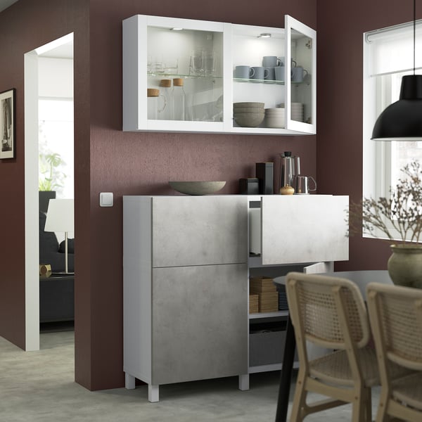 Modern kitchen with glass doors showing dishes above gray cabinets.