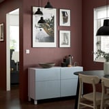 Modern kitchen with BESTÅ storage, maroon wall, plants.