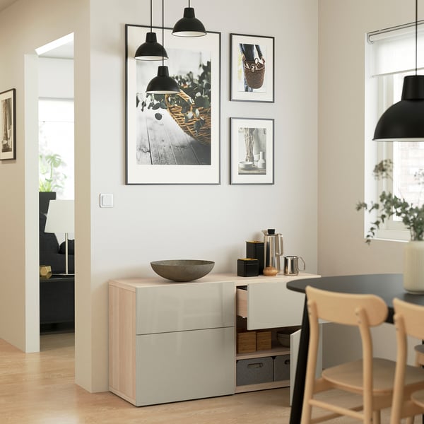 Modern dining room with BESTÅ storage, soft-close drawers, and artwork.