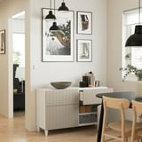 Minimalist sideboard with shelves & drawers, decorative bowl, photos, & pendant lights, in open living space.