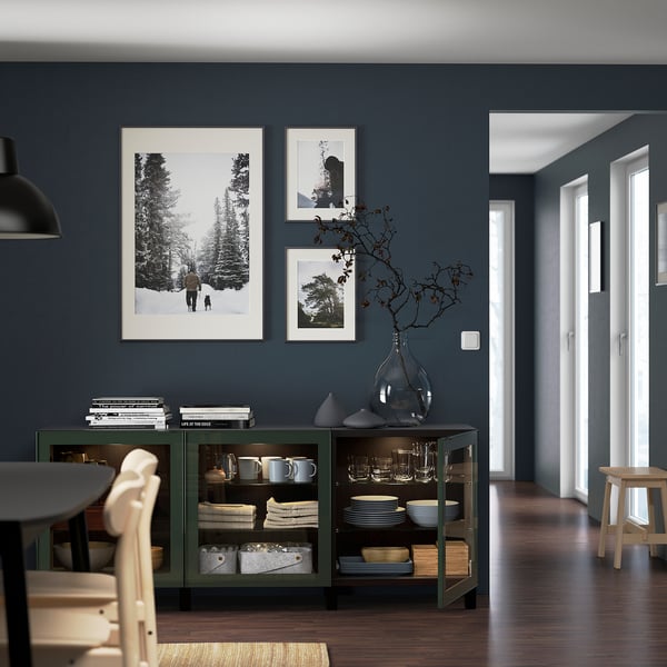 Dining room with blue walls, wood floor, green sideboard, and three pictures.