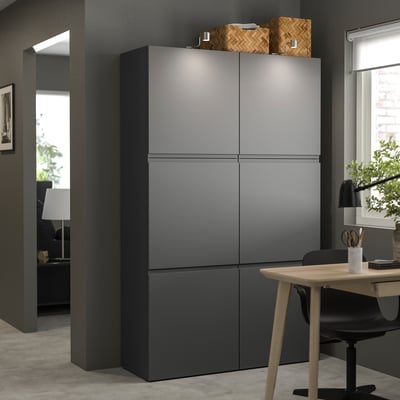 Modern dark gray BESTÅ cabinet in room. Tall, square storage with wooden accents. Clean, minimalist design.