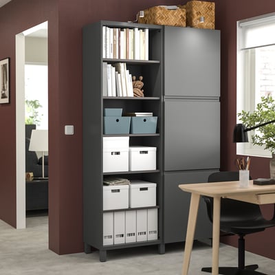 Brown storage unit with shelves, books, & decor, gray/white boxes, near office desk & black chair.