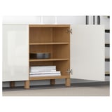 Open wooden shelving unit with books and a bowl. Part of BESTÅ storage combination.