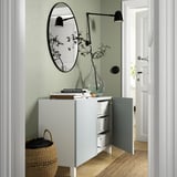 Modern hallway with BESTÅ sideboard, adjustable shelves, wall lamp, large mirror, and decorative vase.
