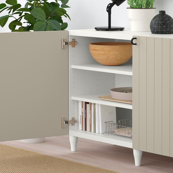 Open shelf unit with wooden bowl, books, and small items, showcasing adjustable shelves and hiding hinges.