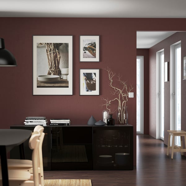 Maroon living room with BESTÅ sideboard, photos, and books.