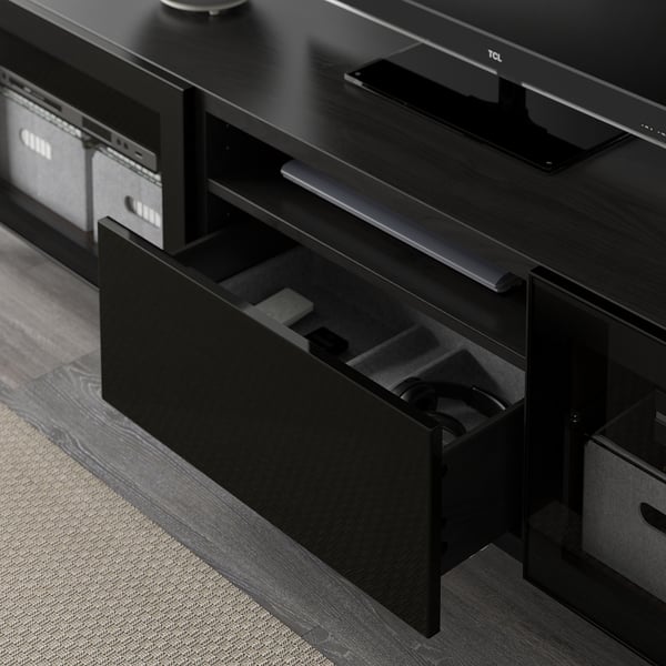 Black tv stand with open drawer, remote-friendly glass doors, and cable management.
