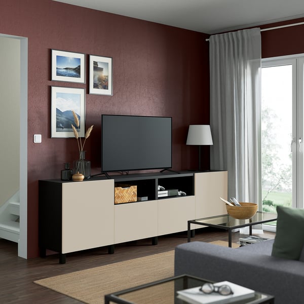 Modern living room with burgundy walls, a BESTÅ tv bench, and grey couch.