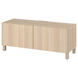 A light wooden tv stand named BESTÅ. It two closed compartments with sleek, minimalist design and adjustable shelves for flexible storage.